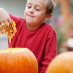 A boy is holding some leaves in his hand.