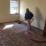 A woman is vacuuming the floor in her home.