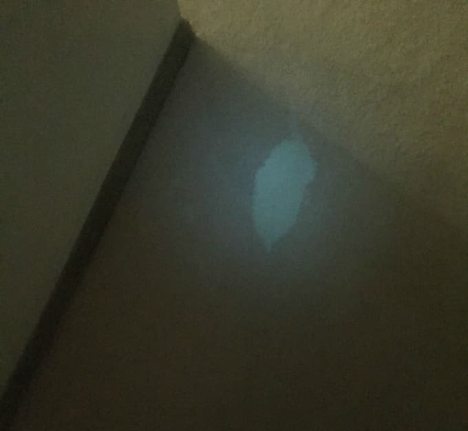 Faint light spot on carpeted floor.