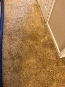 A carpet cleaning machine is in the middle of a room.