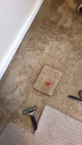 A piece of carpet on the floor with scissors and other items.