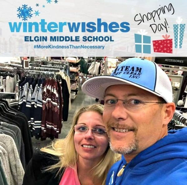 A man and woman posing for a picture in front of a store.