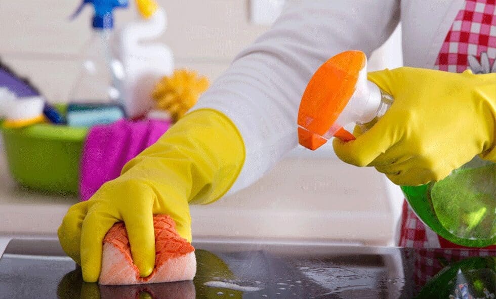 Person cleaning a surface with a sponge.