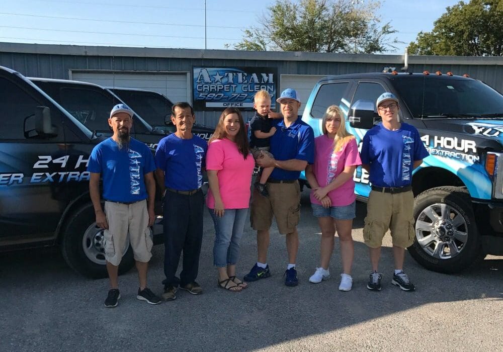 A group of people standing in front of some cars.