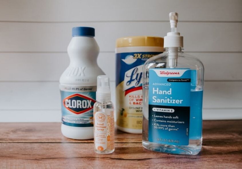 A table with cleaning supplies and hand sanitizer.