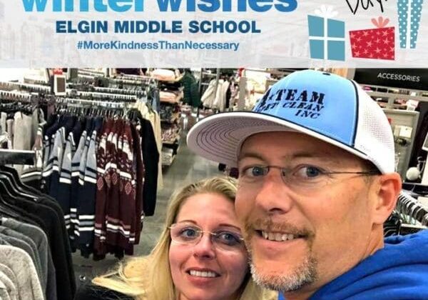 A man and woman posing for a picture in front of a store.